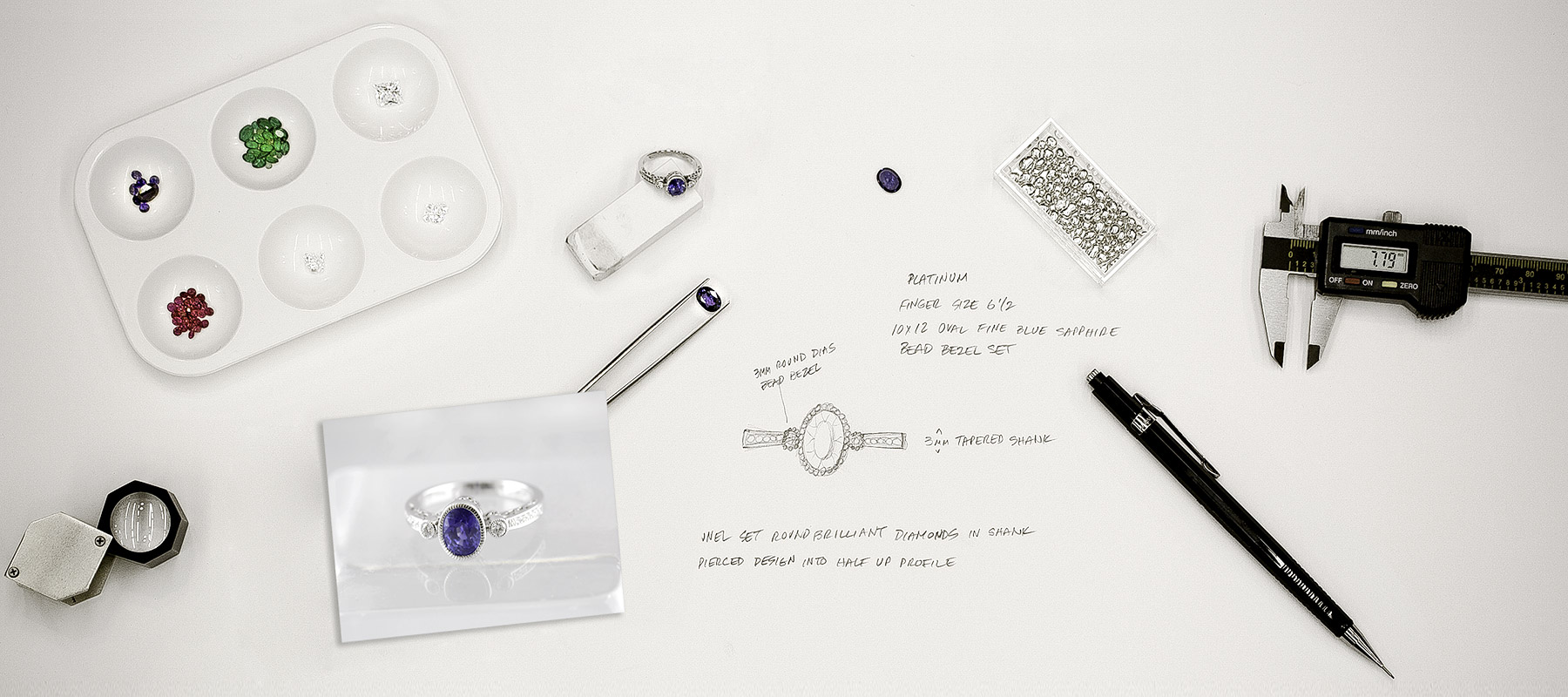 The jewelry designer table with tools and sketches